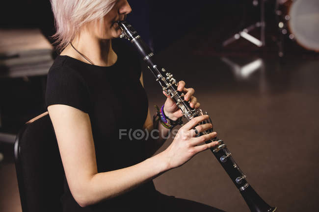 Étudiante jouant de la clarinette dans un studio — Photo de stock