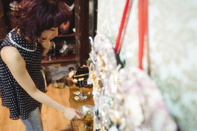 Стильная женщина выбирает чашку в антикварных магазинах — стоковое фото