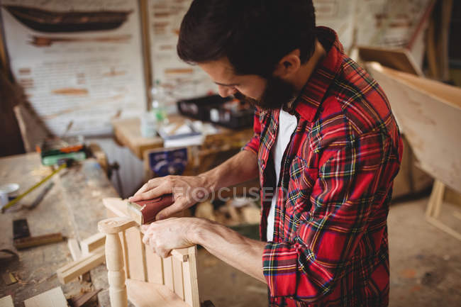 Homme travaillant sur une planche de bois au chantier naval — Photo de stock