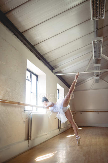 Bailarina praticando dança de balé no barre em estúdio — Fotografia de Stock