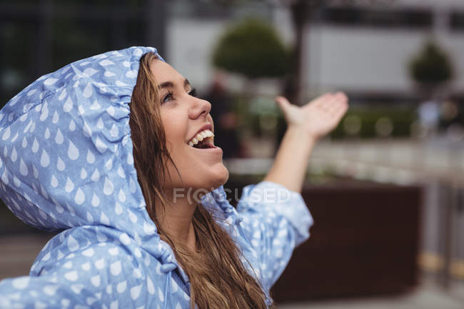 Feliz hermosa mujer disfrutando de la lluvia durante la temporada de lluvias - foto de stock