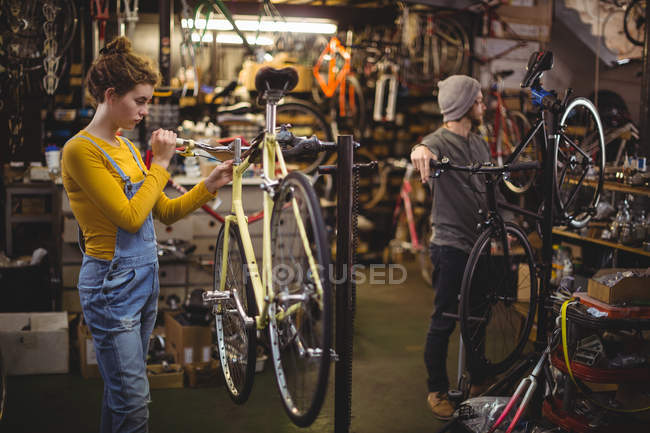 Mecánico reparando una barra de manija de bicicleta en taller de bicicleta - foto de stock