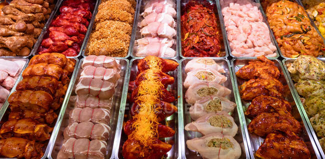 Variété de viande marinée au comptoir de la boucherie — Photo de stock