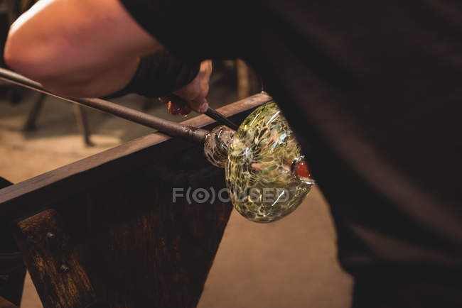 Обрезанное изображение стеклодува, формирующего расплавленное стекло на стекольном заводе — стоковое фото