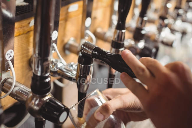 Primer plano de la barra de llenado de cerveza de la barra de la bomba en el mostrador de bar - foto de stock