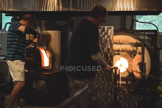 Equipe de sopradores de vidro de aquecimento de vidro em forno na fábrica de sopro de vidro — Fotografia de Stock