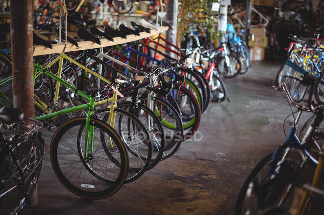 Bunte Fahrräder reihenweise in Werkstatt aufgestellt — Stockfoto