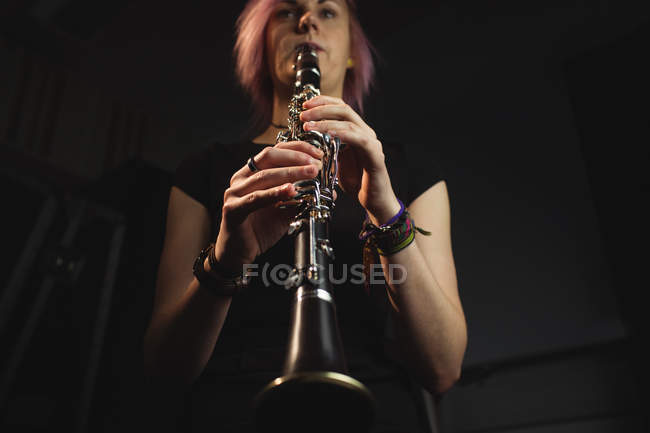 Bella donna che suona un clarinetto nella scuola di musica — Foto stock