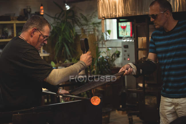 Team of glassblowers shaping molten glass at glassblowing factory — Stock Photo