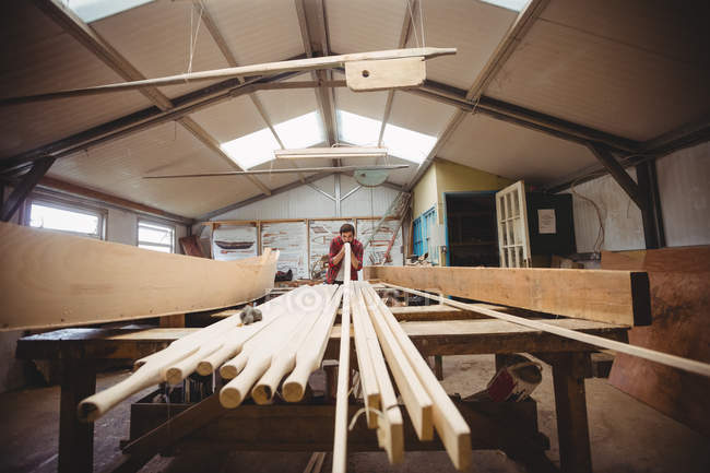 Mann arbeitet auf Bootswerft über Holzplanke — Stockfoto