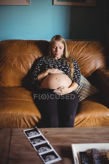 Femme enceinte se détendre dans le salon à la maison — Photo de stock