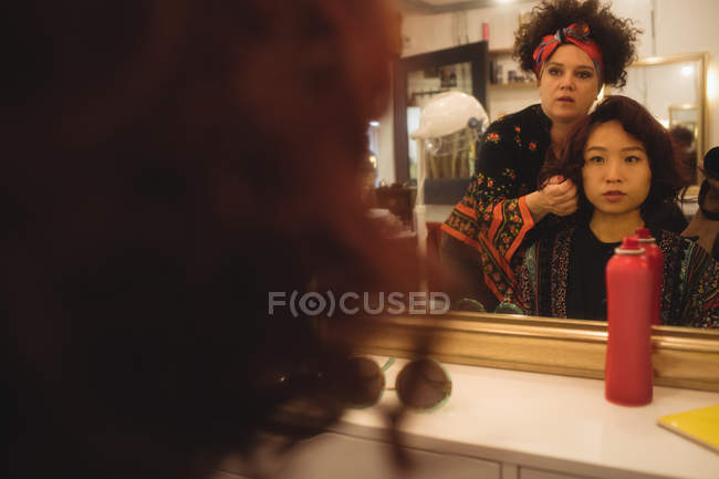 Mulher elegante recebendo cabelo feito em um salão de cabeleireiro profissional — Fotografia de Stock