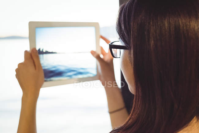 Gros plan de la femme prenant une photo du paysage urbain sur tablette numérique — Photo de stock