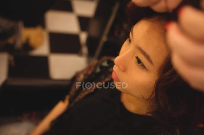 Mulher elegante recebendo seu cabelo feito em um salão de cabeleireiro profissional — Fotografia de Stock