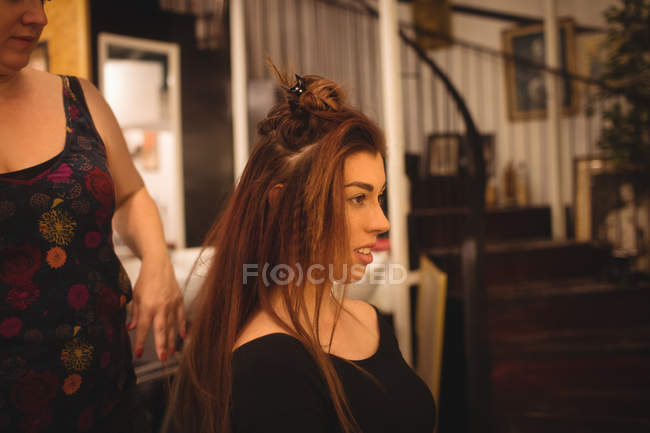 Beautiful woman styling her hair at saloon — Stock Photo