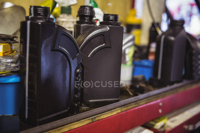 Primer plano del aceite de motor en estante en taller mecánico industrial - foto de stock