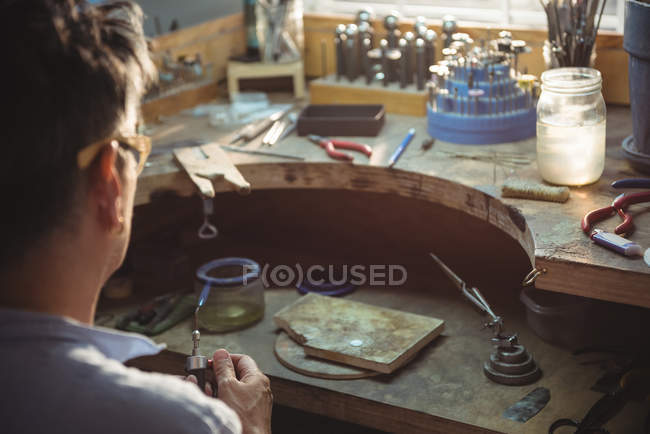 Handwerker hält Fackel in Werkstatt — Stockfoto