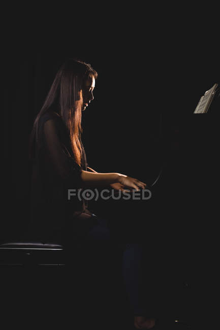 Estudiante tocando el piano en un estudio - foto de stock