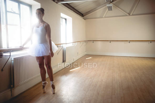 Bailarina practicando danza de ballet en barre en estudio - foto de stock