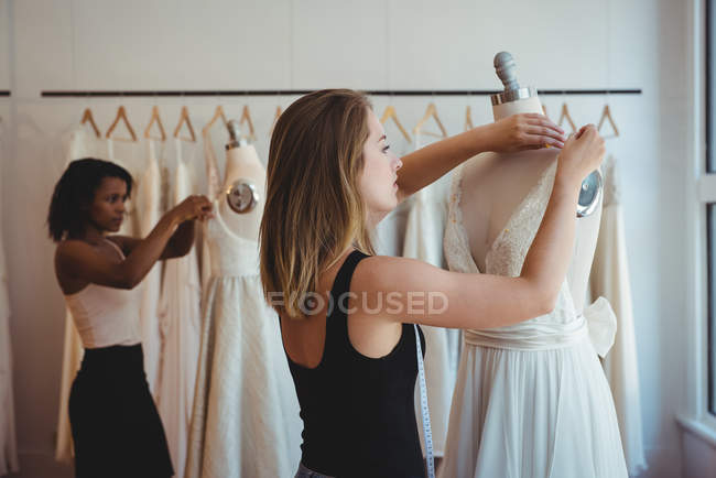 Modedesignerinnen passen Kleid an Schaufensterpuppe im Atelier an — Stockfoto