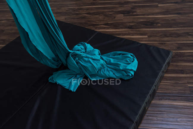 Corde en tissu bleu sur tapis d'atterrissage de gymnastique dans un studio de fitness — Photo de stock