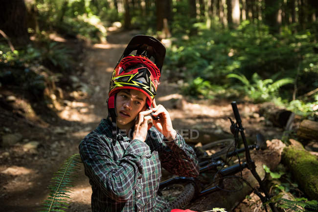 Atleta masculino usando capacete de bicicleta no campo — Fotografia de Stock