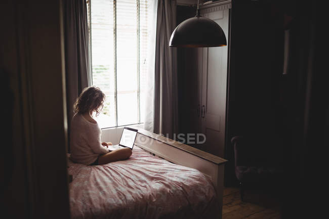 Mulher usando laptop no quarto em casa — Fotografia de Stock