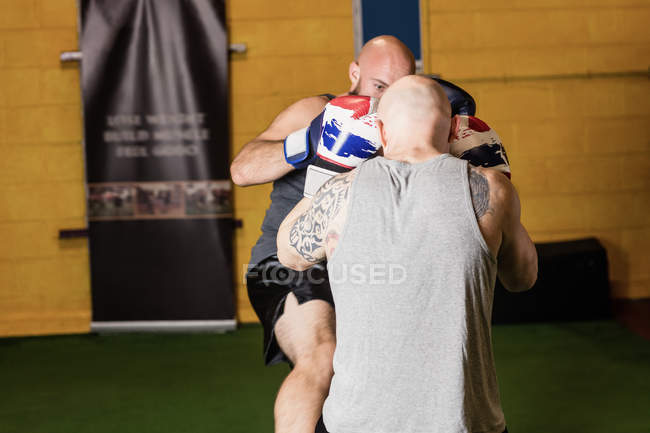 Vista trasera de dos boxeadores tailandeses practicando boxeo en gimnasio - foto de stock