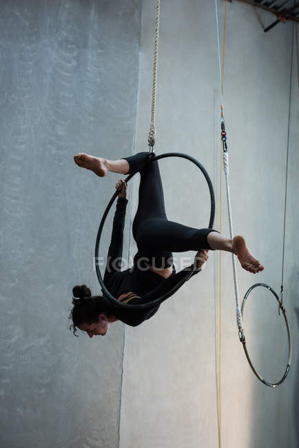 Giovane donna che esegue ginnastica su cerchio in palestra — Foto stock