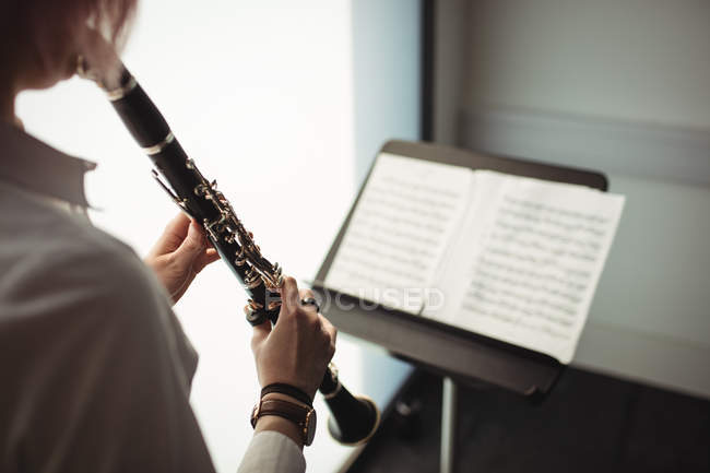 Metà sezione di donna che suona un clarinetto nella scuola di musica — Foto stock