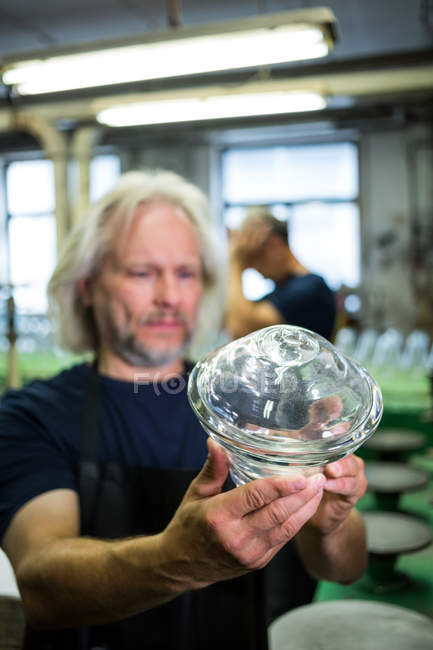 Sopladores de vidrio examinando artículos de vidrio en la fábrica de soplado de vidrio - foto de stock