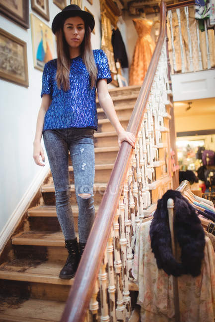Female staff standing on staircase in boutique store — Stock Photo