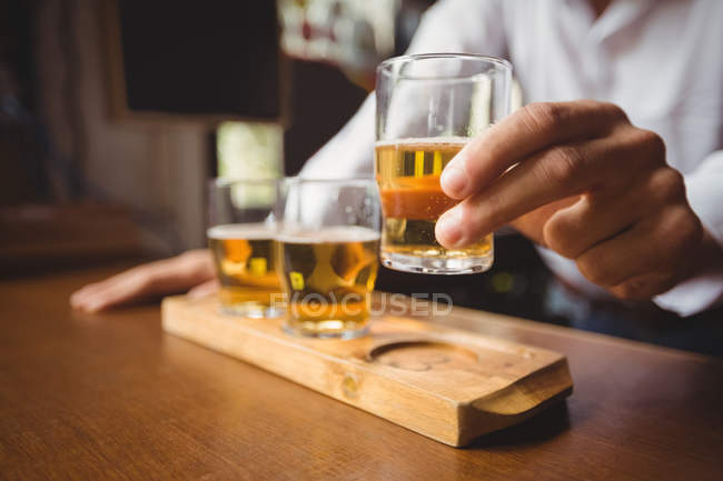 Close-up of bartender holding whisky shot glass at bar counter in bar — Stock Photo