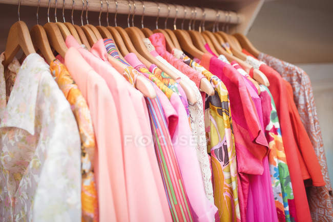 Різний барвистий одяг на вішалках в магазині — стокове фото