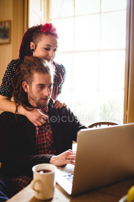 Пара хипстеров использует ноутбук дома — стоковое фото