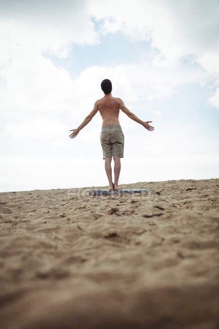 Вид сзади на человека, стоящего на пляже — стоковое фото