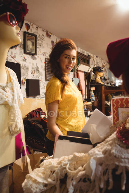 Retrato de una hermosa mujer sonriendo en una tienda de antigüedades - foto de stock