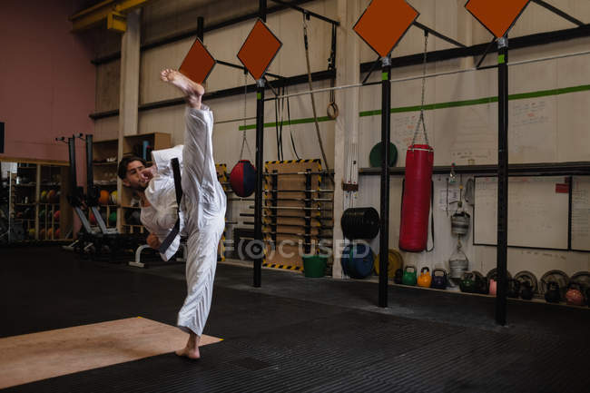 Homme pratiquant le karaté dans un studio de fitness — Photo de stock