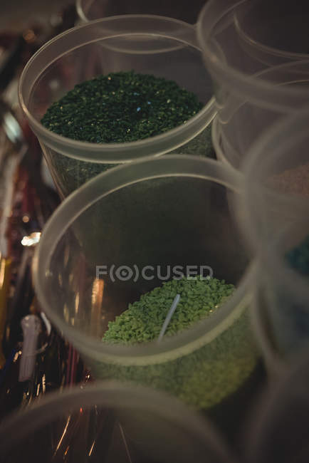 Close-up of frit glass in plastic containers at glassblowing factory — Stock Photo