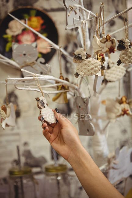 Mão de mulher segurando decoração de ovelhas antigas na loja de antiguidades — Fotografia de Stock
