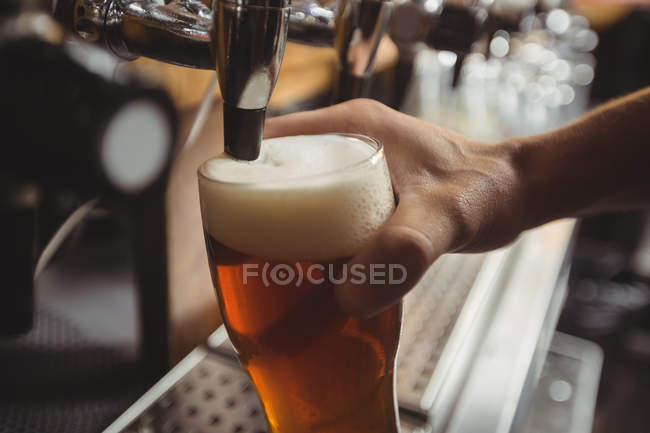 Крупный план заполнения бара тендером пива из барного насоса на стойке бара — стоковое фото