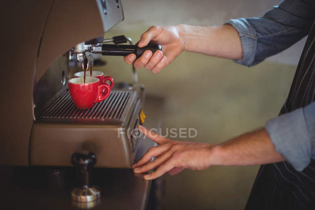 Mittelteil des Kellners kocht Kaffee im Café in der Werkstatt — Stockfoto