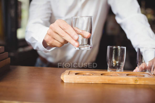 Бармен організовує пивний келих на лотку за барною стійкою в барі — стокове фото