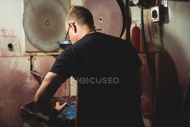 Vetro soffiatore esaminando vetreria presso la fabbrica di soffiaggio vetro — Foto stock