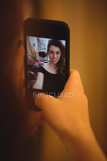 Mujer tomando selfie desde el teléfono móvil en el salón de belleza - foto de stock