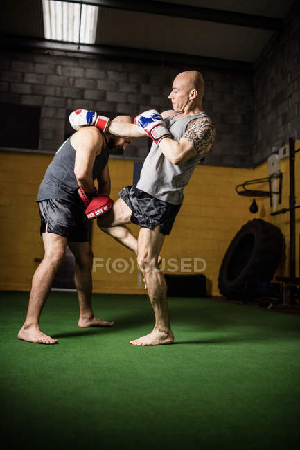 Seitenansicht von zwei Muay Thaiboxern, die im Fitnessstudio üben — Stockfoto