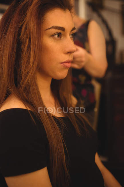 Young brunette styling her hair at beauty saloon — Stock Photo