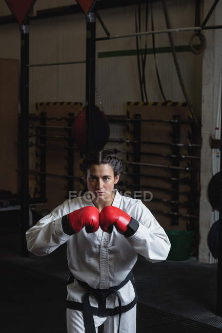 Портрет женщины-боксера в красных боксёрских перчатках в фитнес-студии — стоковое фото