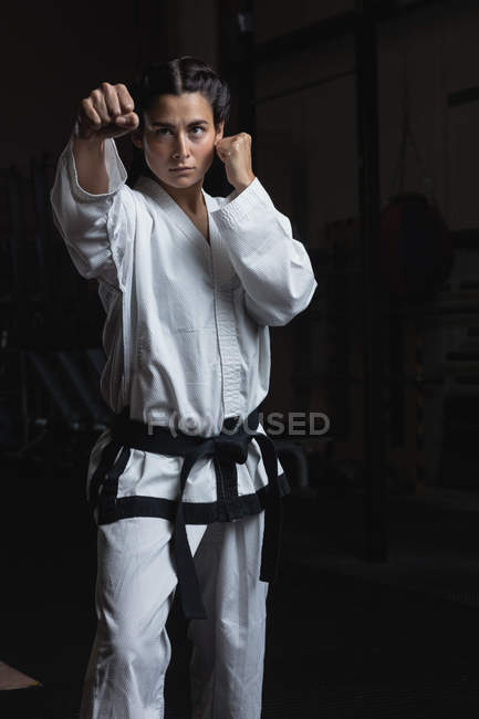 Sportswoman practicing karate in fitness studio — Stock Photo
