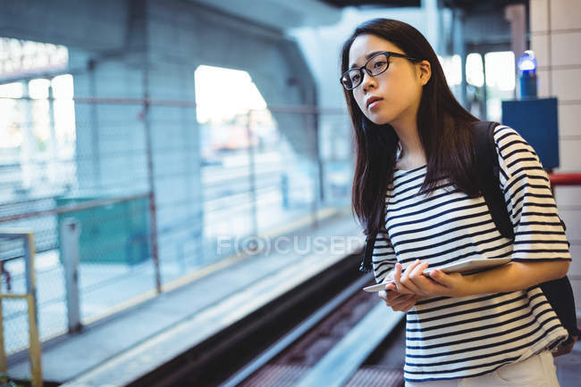 Giovane donna in attesa di treno alla stazione ferroviaria — Foto stock